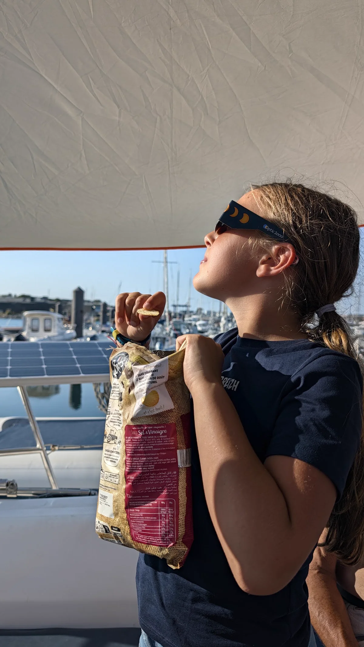 Manon avec ses lunettes d'éclipse et son paquet de chips bretonnes